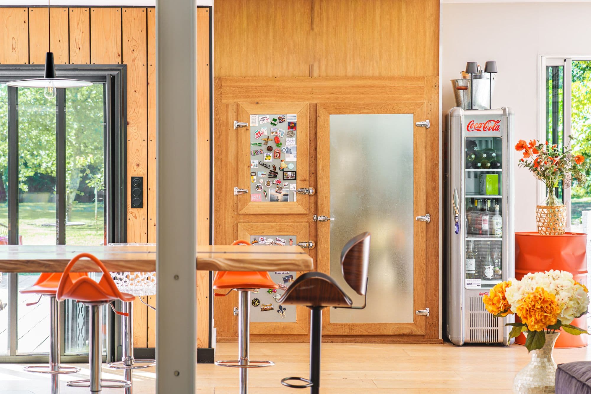 Le bar de la cuisine, tabourets orange, ouvert sur le parc