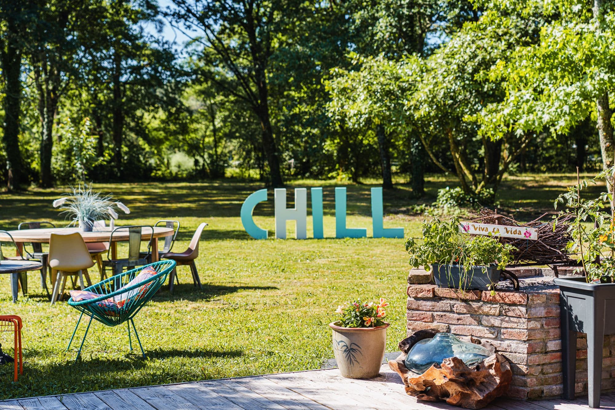 Tables et transats installés dans le parc pour une garden party, lettres CHILL