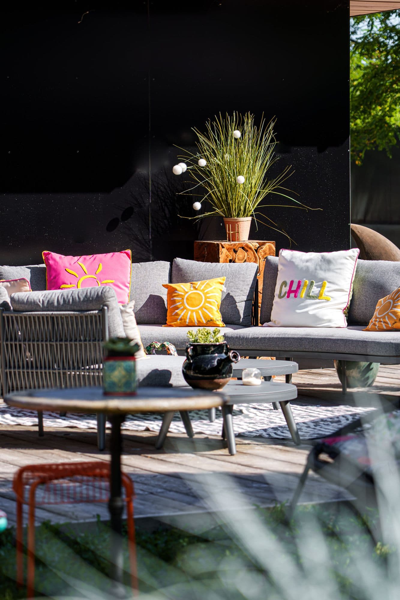 Le salon d'extérieur aux coussins fuchsia dans la lumière
