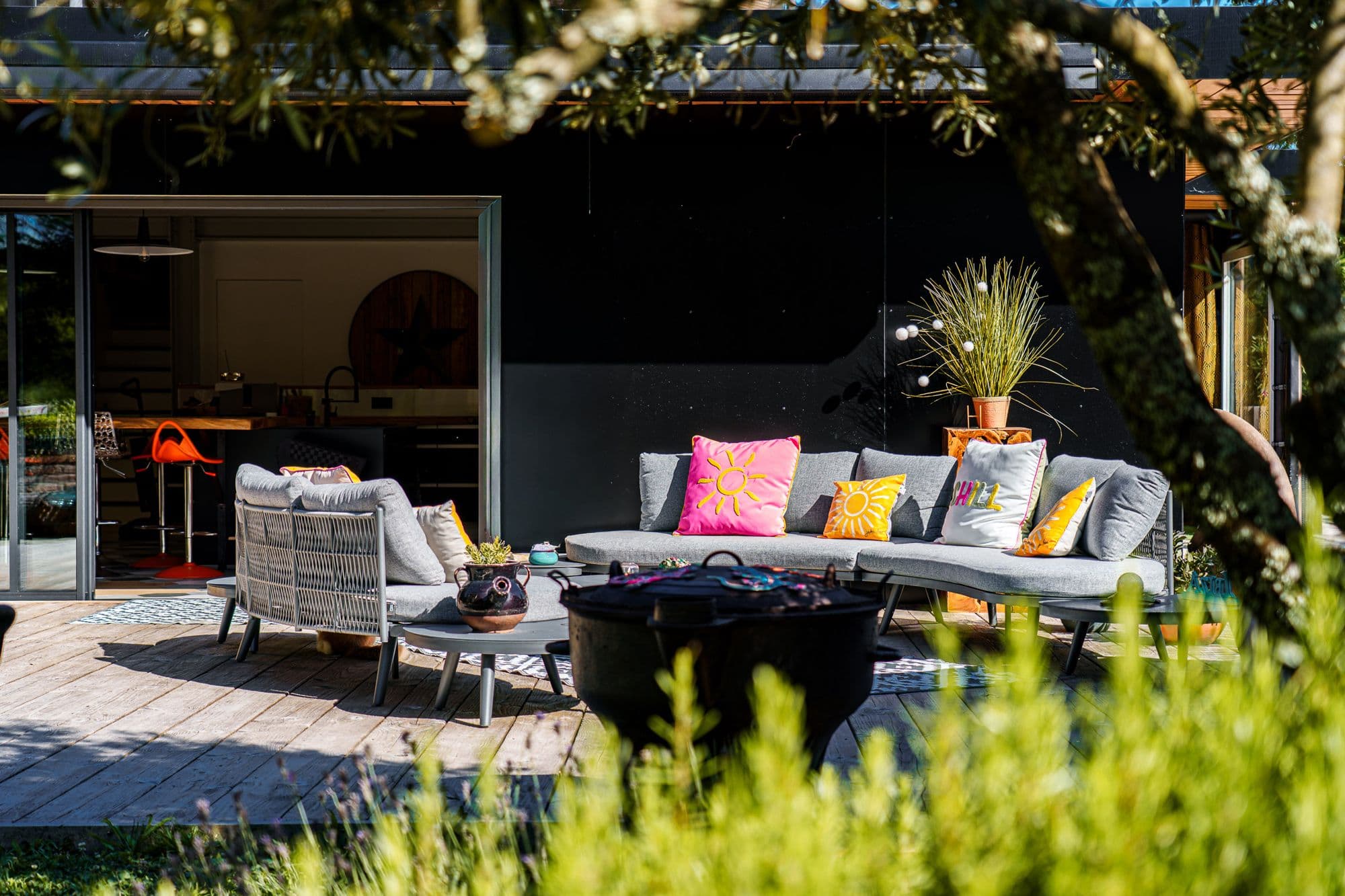 La terrasse lounge au matin, la maison ouverte derrière