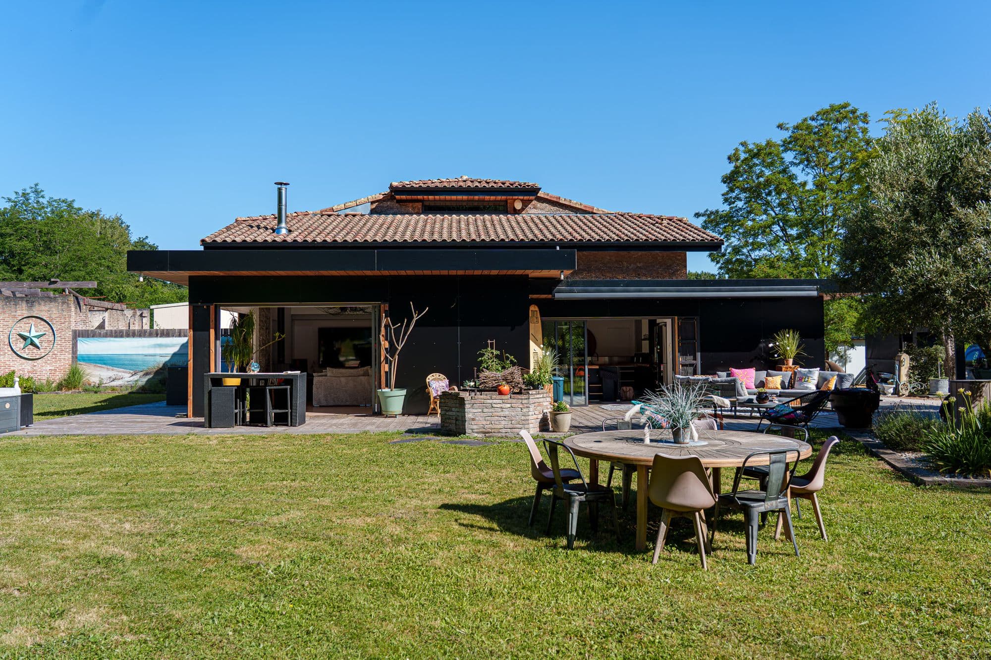 La maison, sa terrasse et la piscine vues du parc