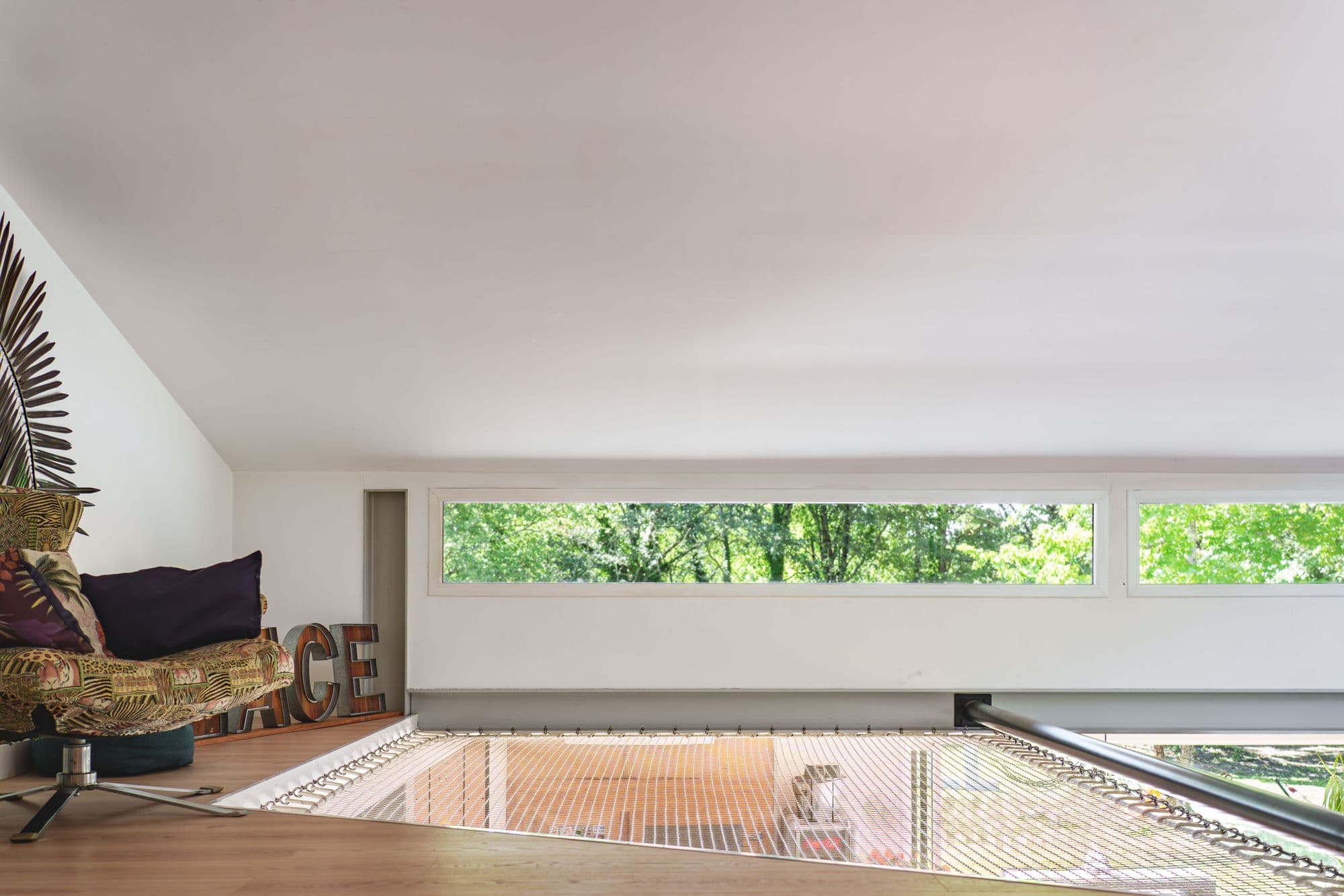 La mezzanine et sa fenêtre en bandeau sur les arbres