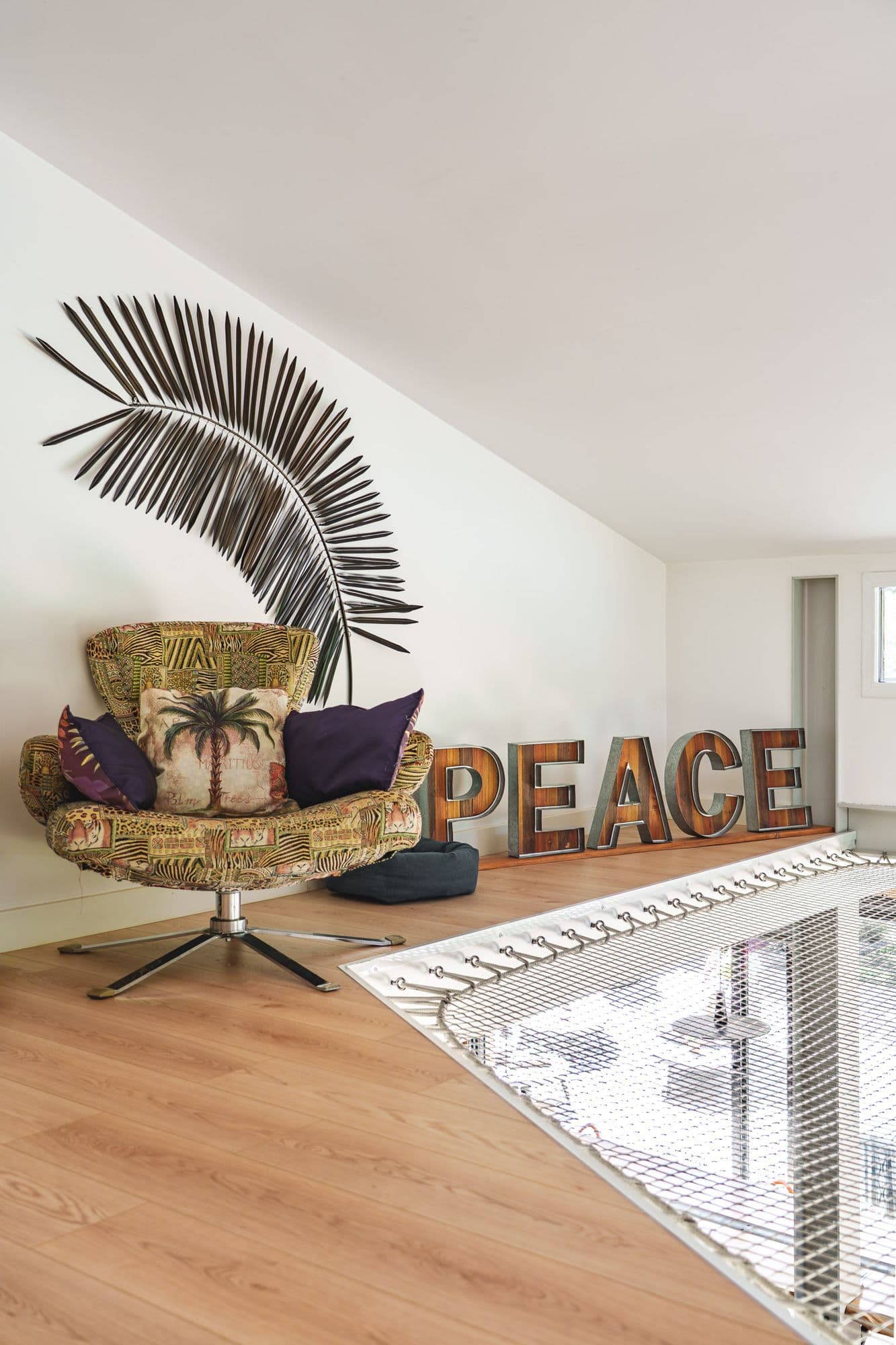 La mezzanine et ses lettres PEACE, fauteuil en rotin